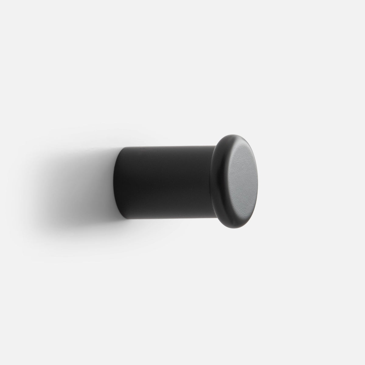 Close-up side view of Remy Single Hook showcasing its cylindrical form and rounded end on a white background
