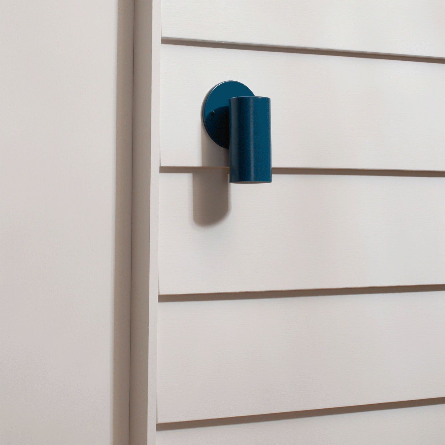 Side view of Eduard Wall Sconce showcasing its closed top on a white paneled wall