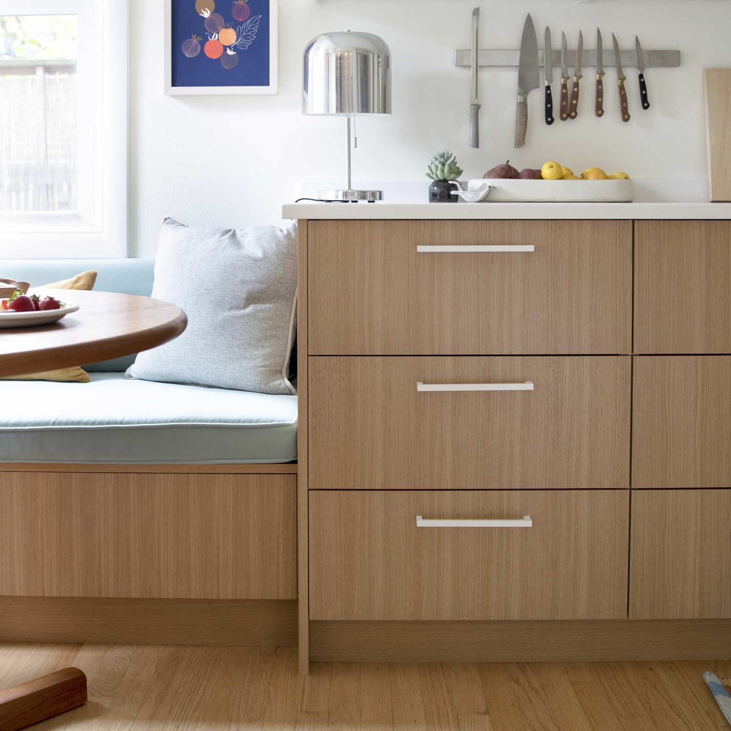 Edgecliff appliance pulls installed on wood cabinetry in a bright kitchen
