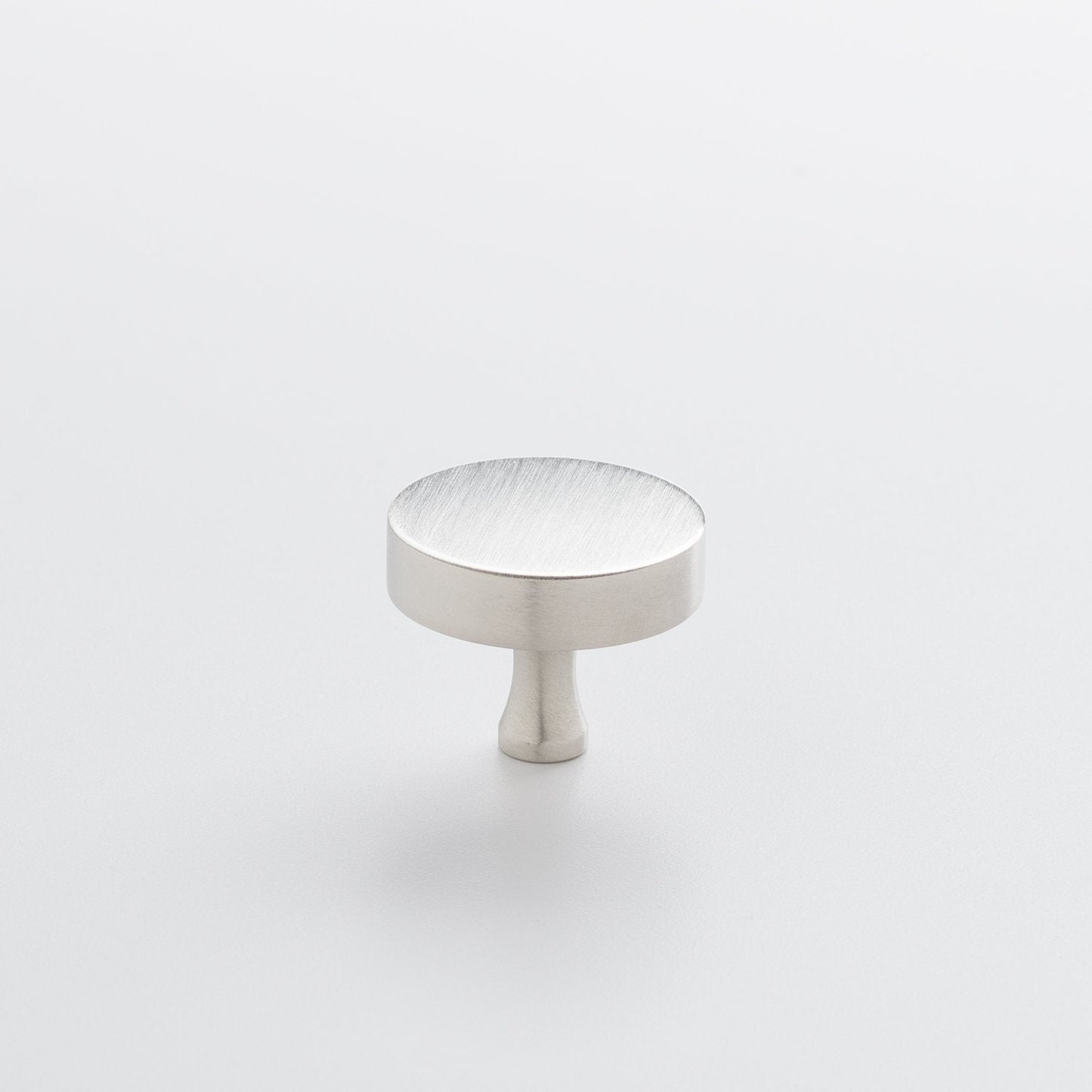Three-quarter view of the Satin Nickel Riverwood Knob showcasing its flat round top and fluted neck on a light background