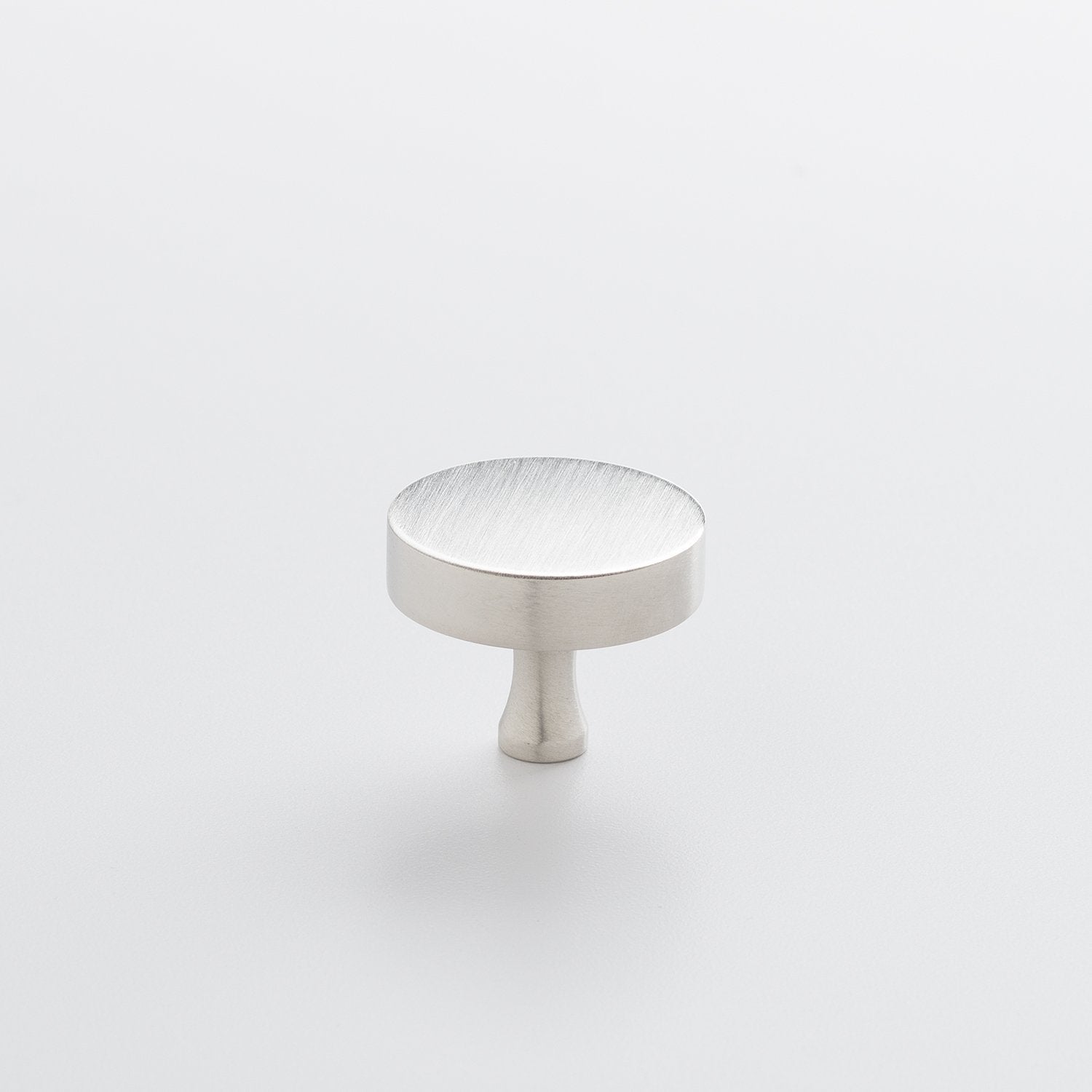 Three-quarter view of the Satin Nickel Riverwood Knob showcasing its flat round top and fluted neck on a light background