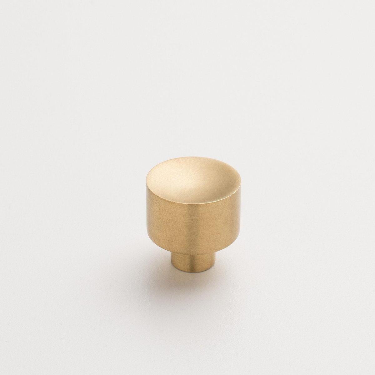 Angled view of Mid Century Knob showcasing cylindrical gold-tone hardware with a plain white background