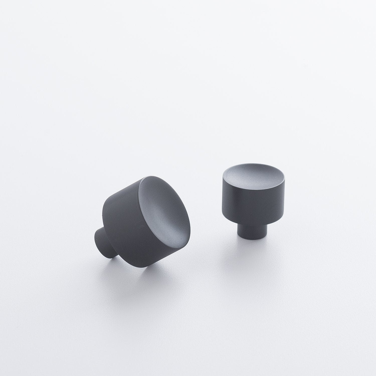 Close-up of Mid Century Knob showcasing its cylindrical black design on a white background