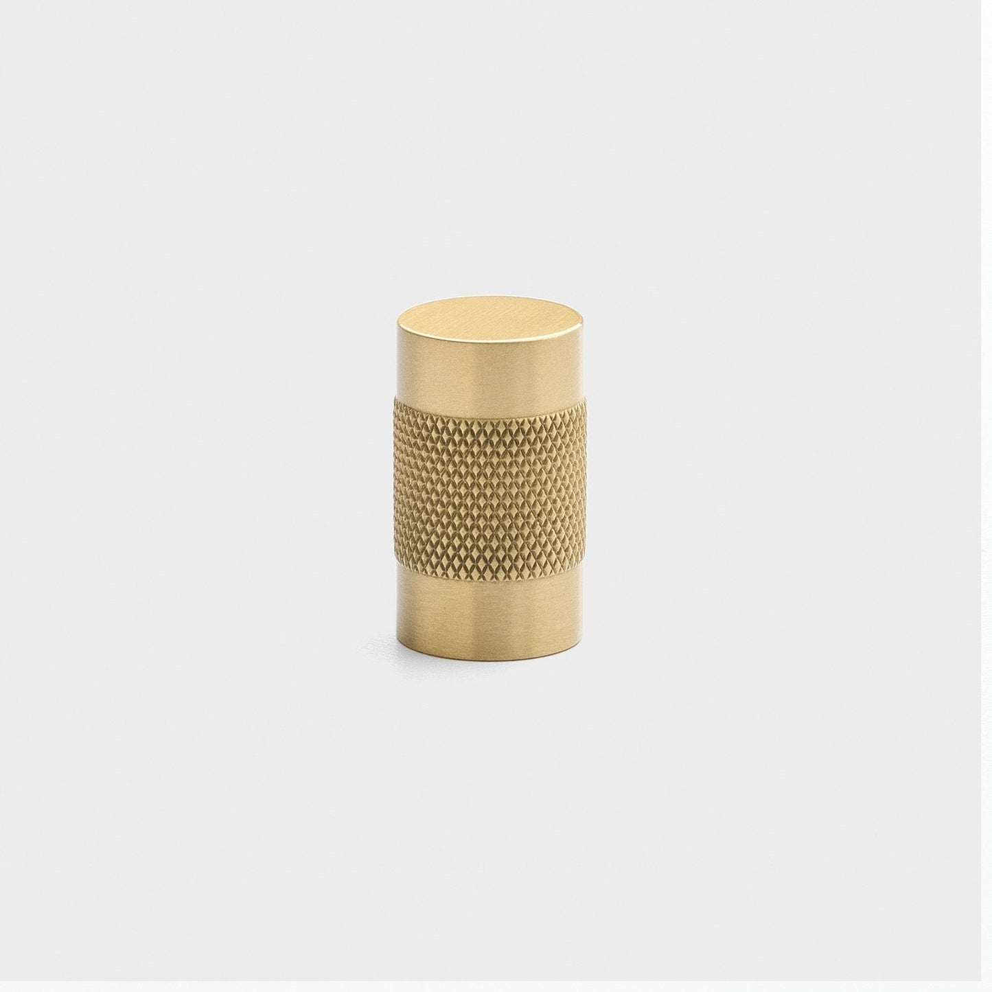 Front view of Knurled Knob showcasing cross-hatched texture in natural brass with a light gray background