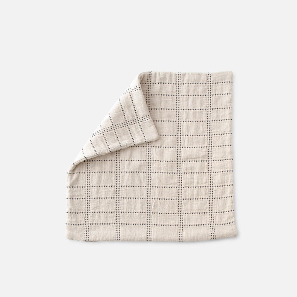Front view of Grid Stitch Pillow Cover showcasing a stitched grid pattern with a folded corner on a light gray background