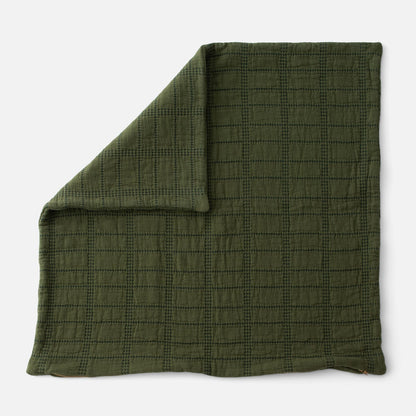Close-up of Grid Stitch Pillow Cover showcasing green grid stitching and folded corner on a white background
