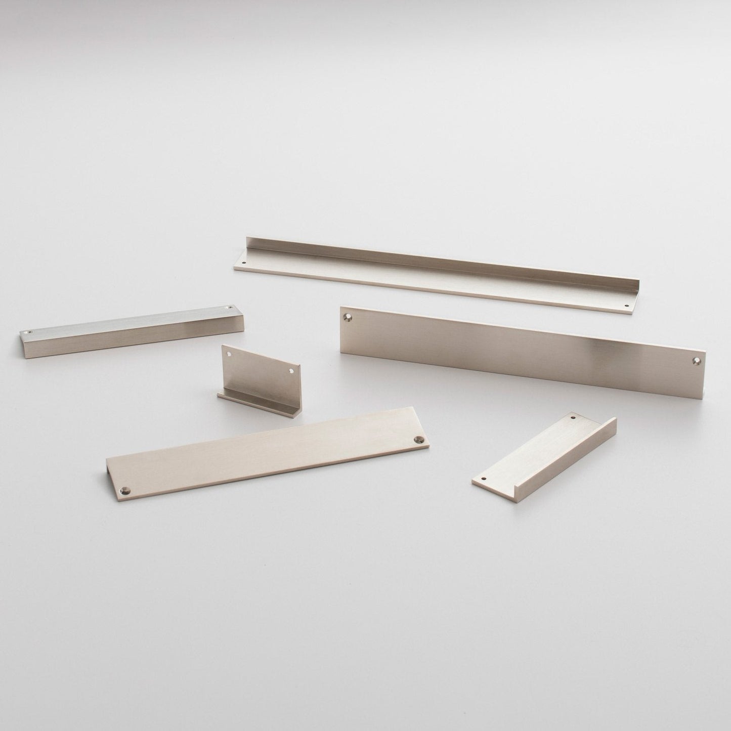 Angled view of the Ledge Pull hardware set showcasing multiple metal components with mounting holes on a light background