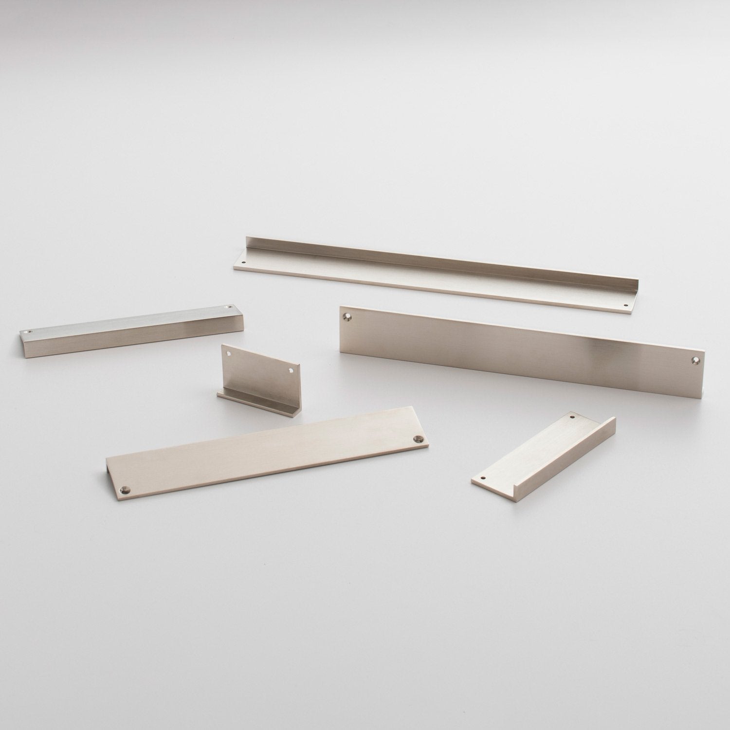 Angled view of the Ledge Pull hardware set showcasing multiple metal components with mounting holes on a light background