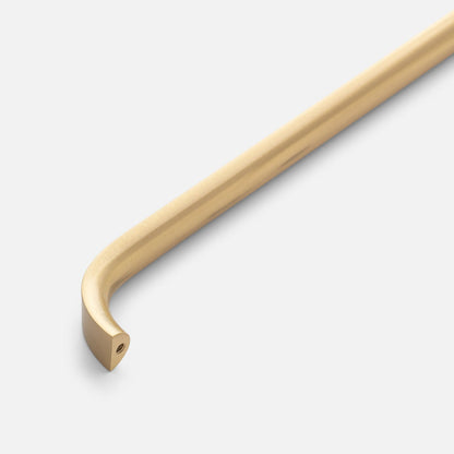 Close-up of Cascade Pull showcasing its curved gold-tone bar and mounting end on a light gray background