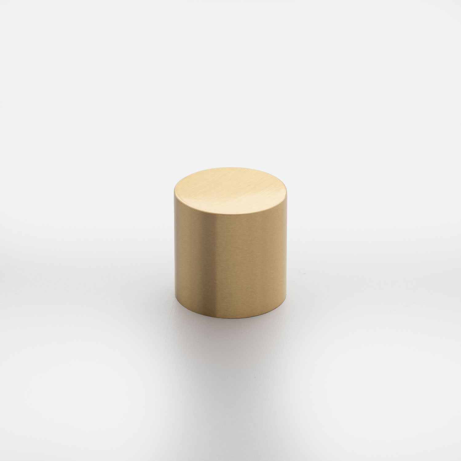 Three-quarter view of Cove Knob showcasing its cylindrical gold finish against a white background