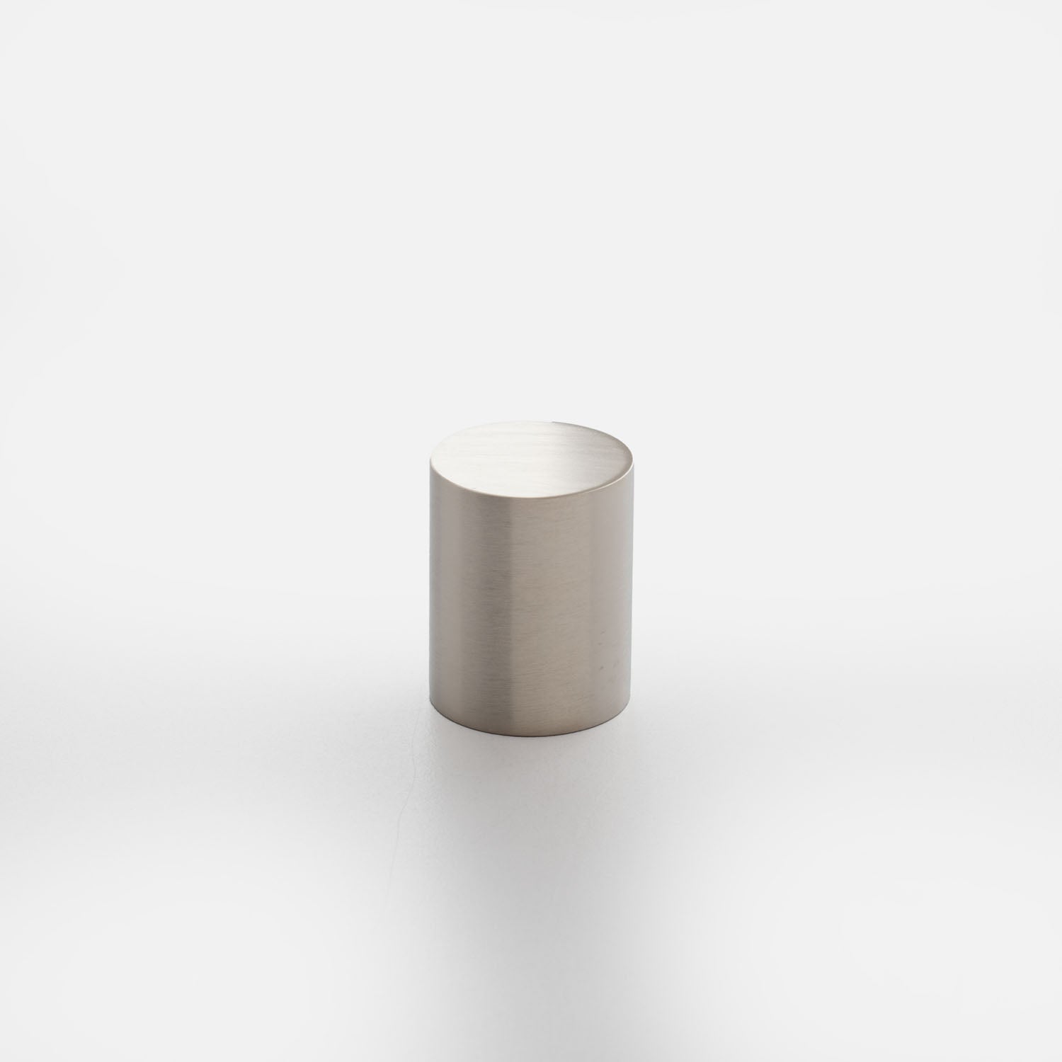 Front view of Cove Knob showcasing its cylindrical shape and brushed metal finish on a white background