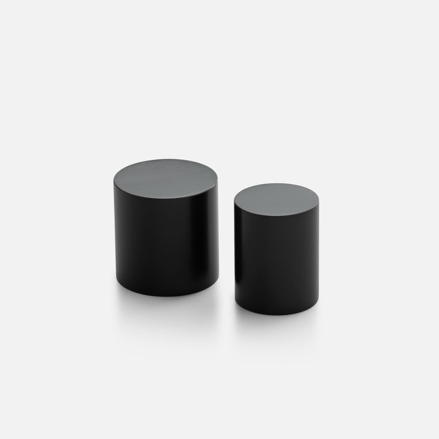 Front angled view of two black Cove Knobs showcasing cylindrical design with a light background