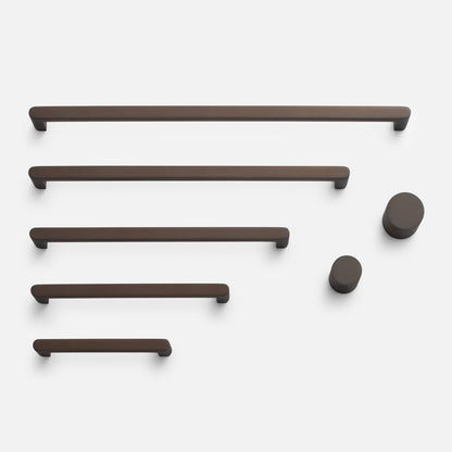 Overhead view of Cove Knob hardware showcasing dark brown bar pulls and round knobs on a white background