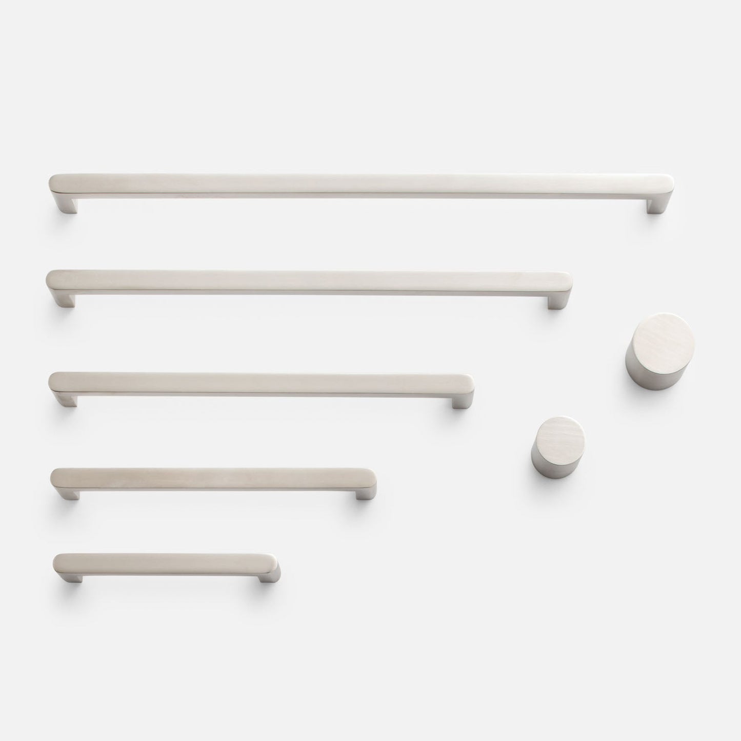Overhead view of Cove Pull hardware showcasing bar pulls and round knobs on a white background