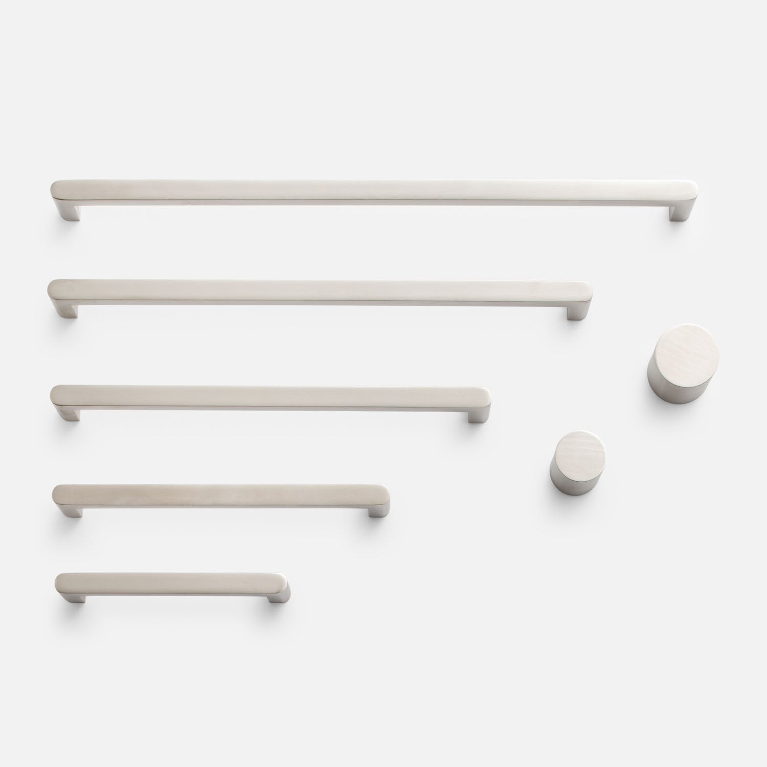 Overhead view of Cove Pull hardware showcasing bar pulls and round knobs on a white background
