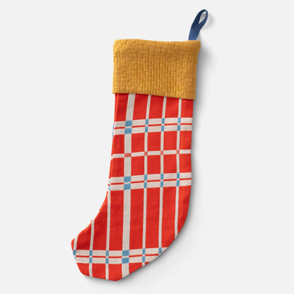 Front view of Shelburne Stocking showcasing its red geometric plaid pattern and mustard woven cuff against a light gray background