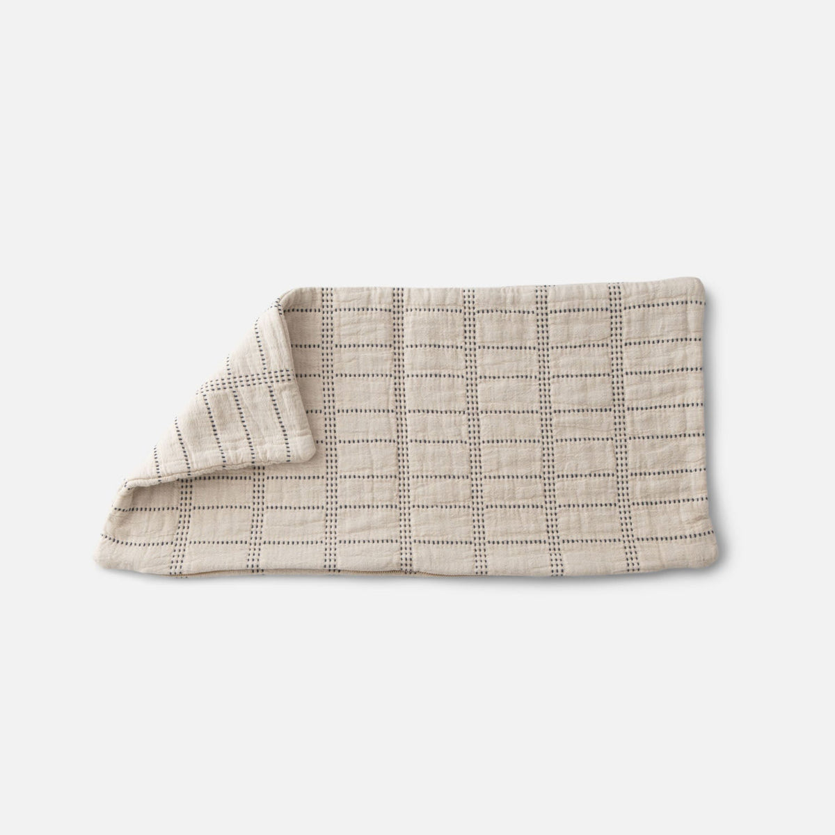 Close-up of Grid Stitch Pillow Cover showcasing cream fabric with a dark stitched grid pattern against a light background
