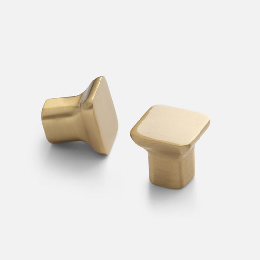 Two views of the Cascade knob showcasing its sloping, modern yet organic silhouette in natural brass on a light background