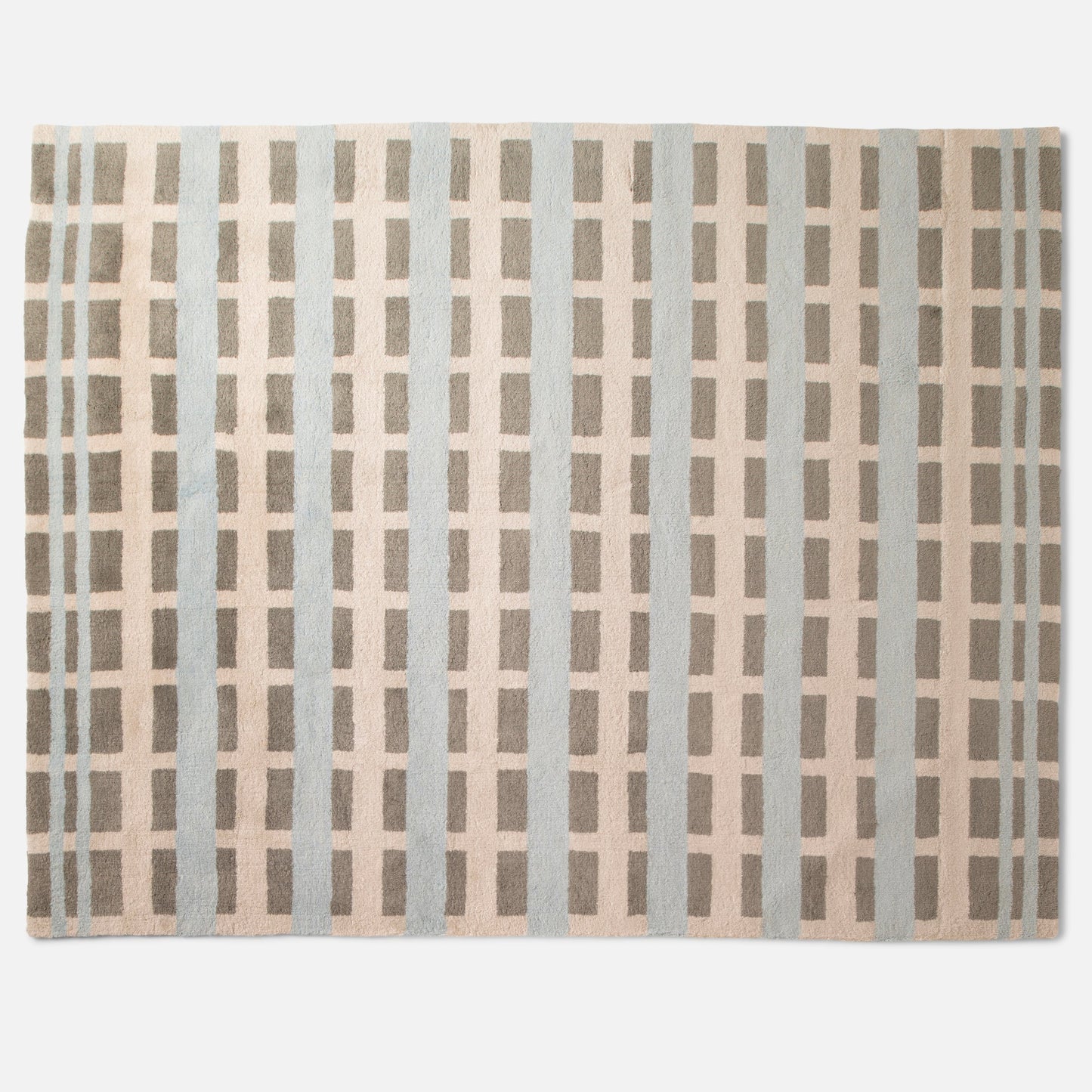 Top-down view of Network Tufted Wool Rug showcasing high-pile geometric grid pattern in soft blue and taupe on white background
