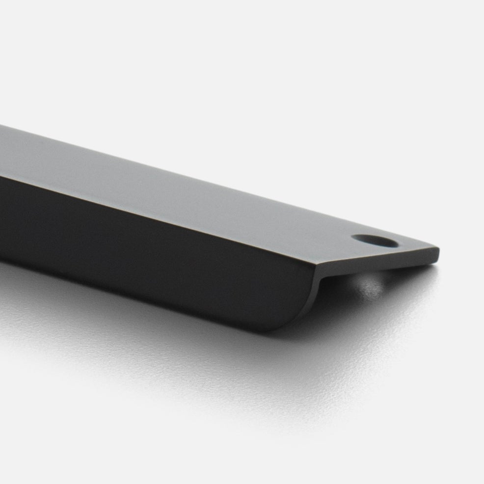 Angled close-up of the black Linn Pull showcasing its elongated rectangular design and mounting hole on a light background