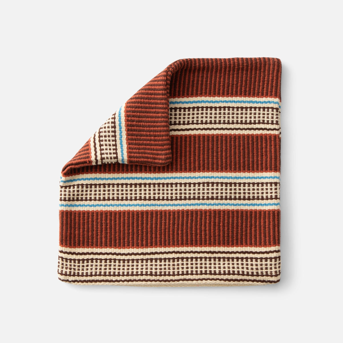 Close-up of Anders Pillow Cover showcasing rust, cream, brown, and blue geometric stripes against a white background