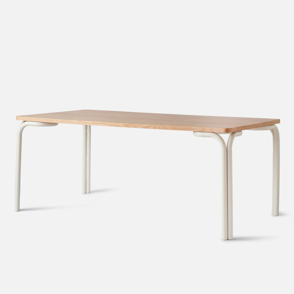 Front three-quarter view of Forma Dining Table showcasing its oak veneer top and powder-coated steel legs against a white background