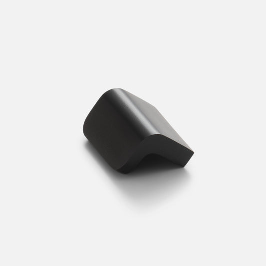 Angled view of the Moore Knob showcasing its curved solid brass design in True Black on a light background