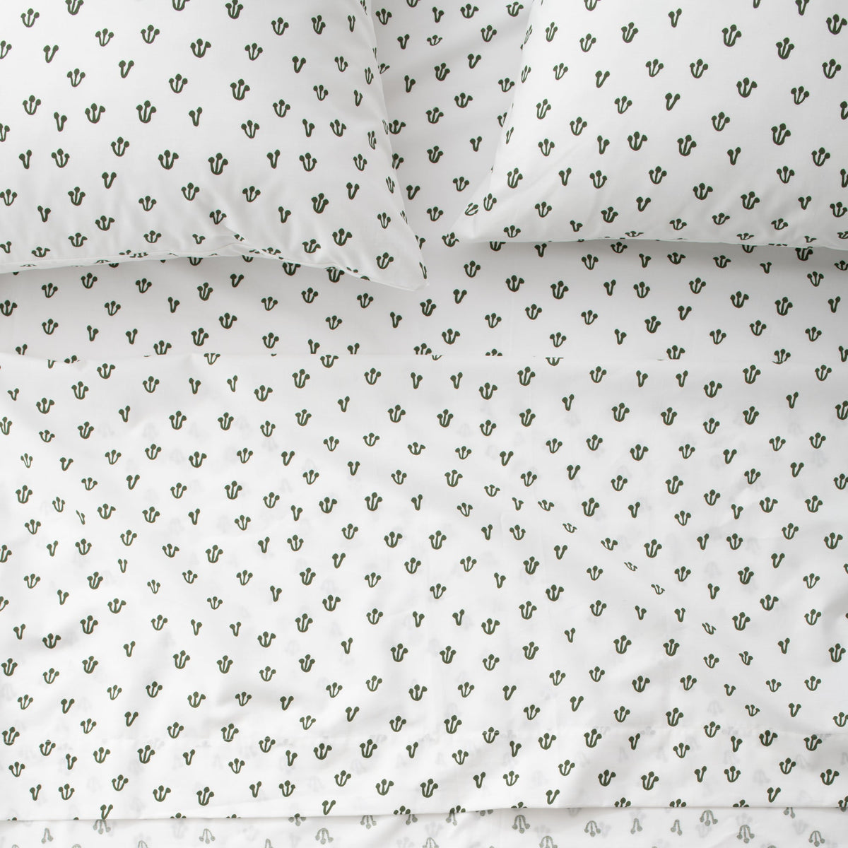Close-up of Thistle Sheet Set showcasing hand-drawn Alder Green thistle pattern on white fabric
