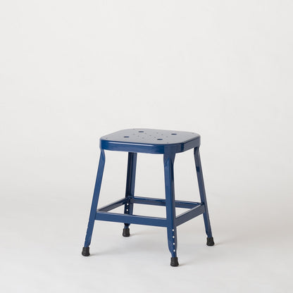 Three quarter view of the Schoolhouse Utility Stool 26 inch in indigo gloss, showing its welded steel frame and stamped seat