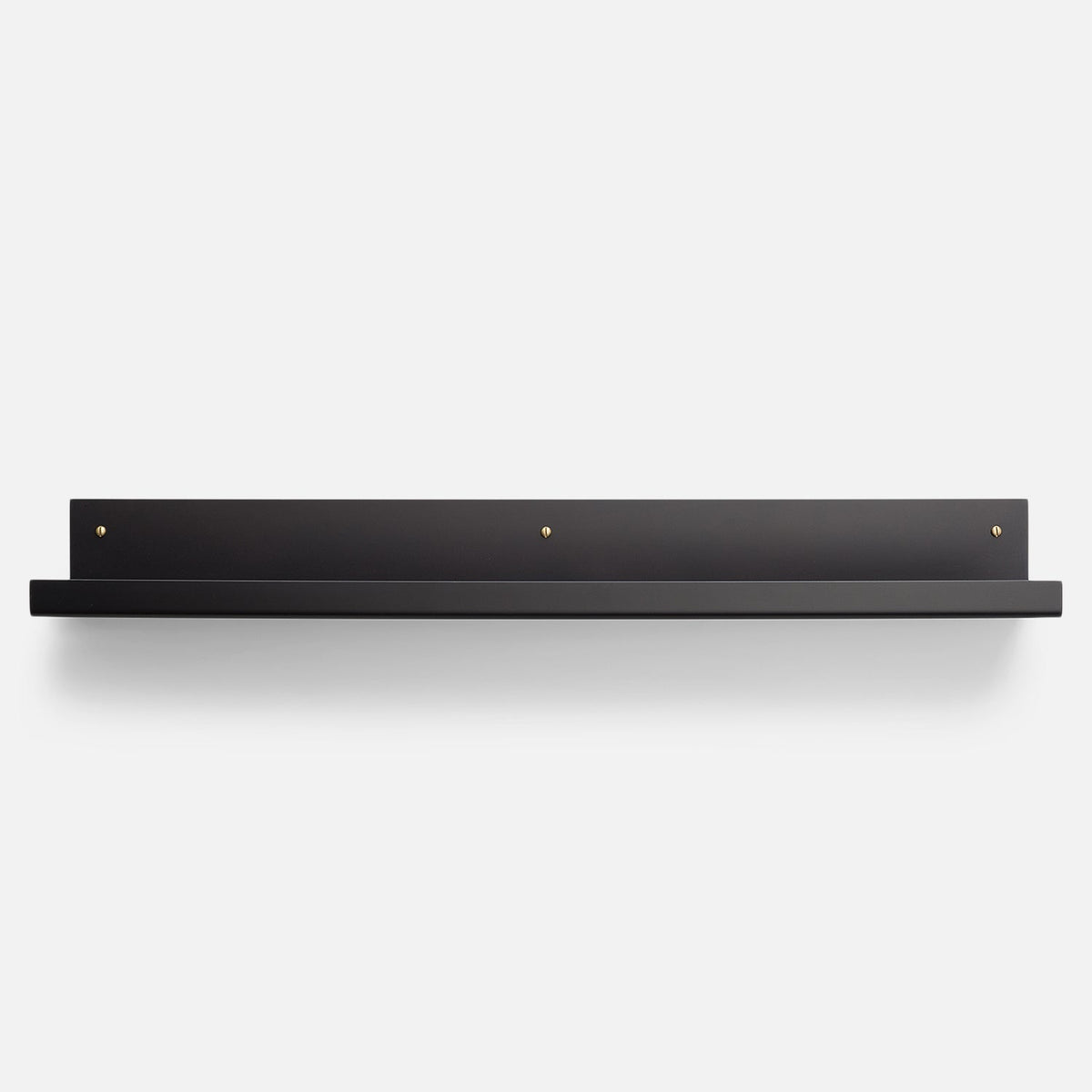 Front view of Brake Angle Picture Ledge showcasing black satin steel shelf and brass mounting hardware on a light background
