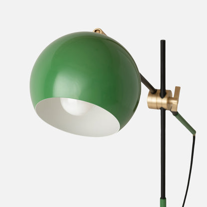 Close-up of green Isaac Desk Lamp showcasing its swiveling shade and brass swivel on a light gray background