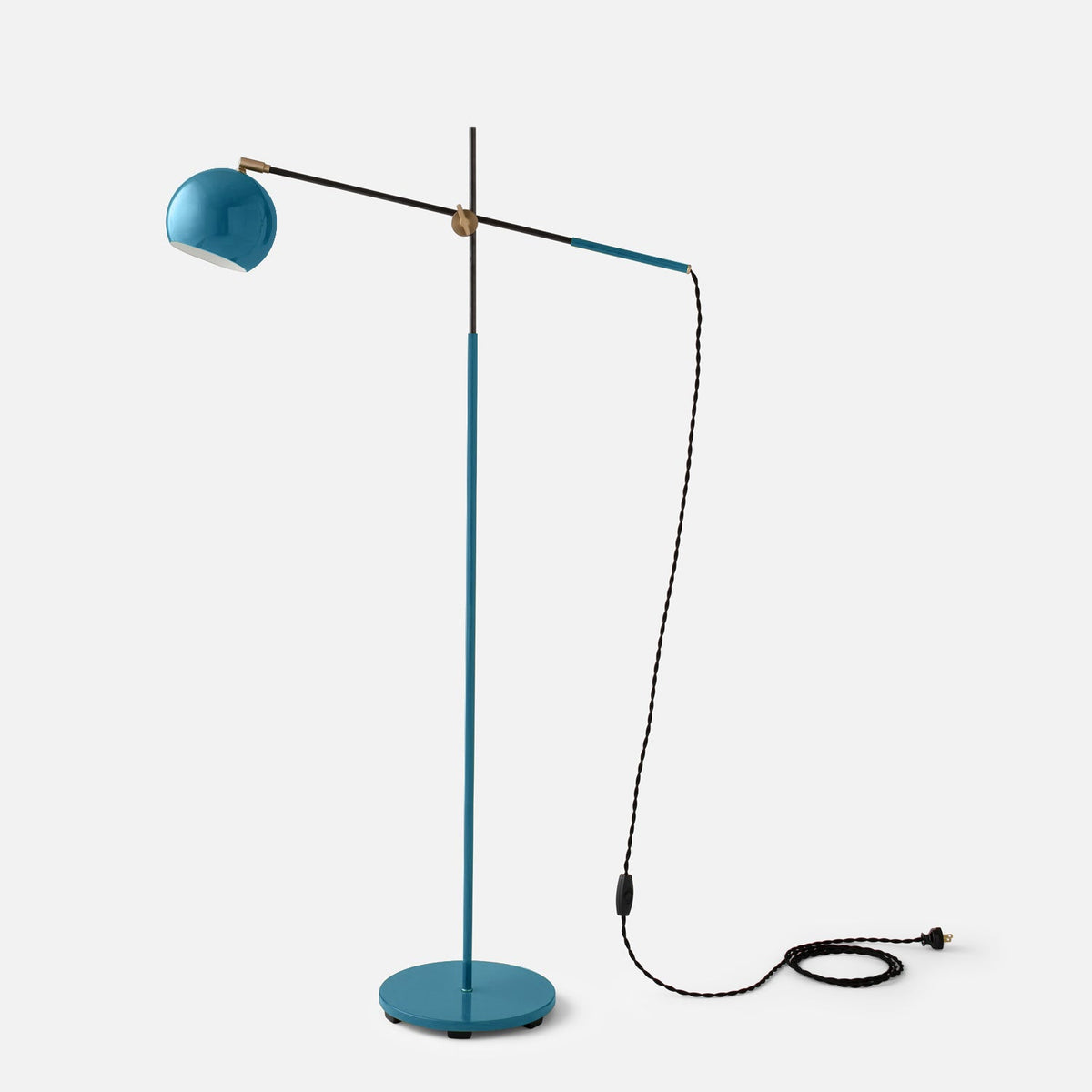 Front view of Isaac Floor Lamp showcasing its Pool Gloss finish, brass swivel, and cast iron base on a light gray background