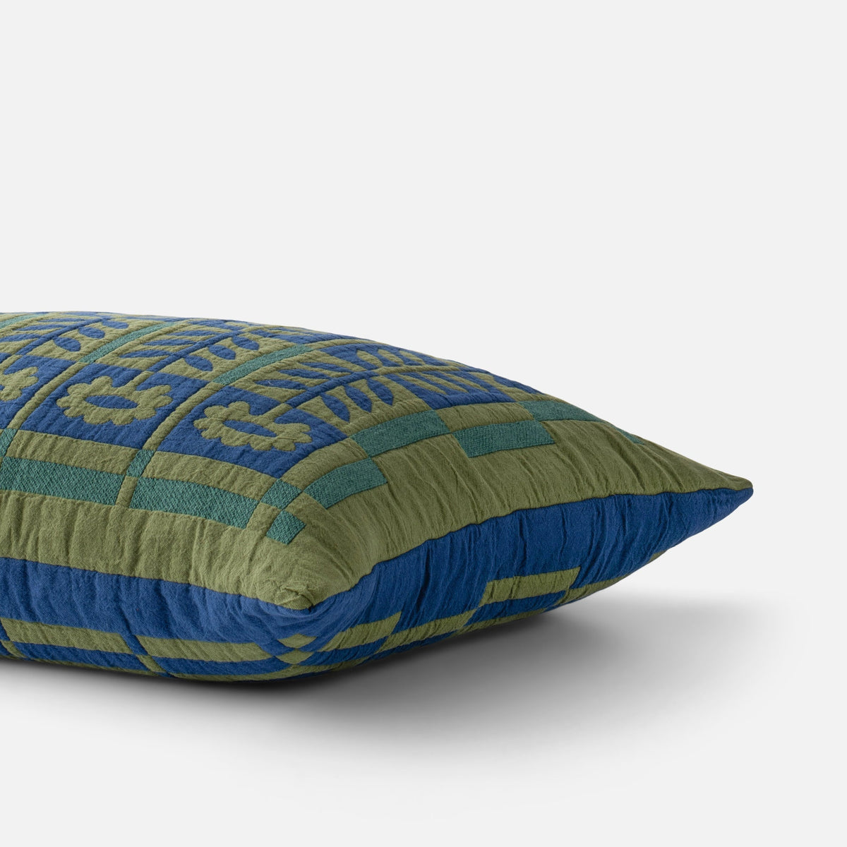 Angled view of Stillwater Sham showcasing blue and green patterned fabric with a white background