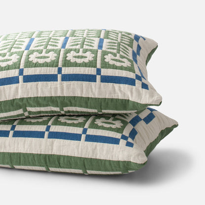 Close-up view of Stillwater Sham showcasing green, blue, and cream geometric pattern on white background