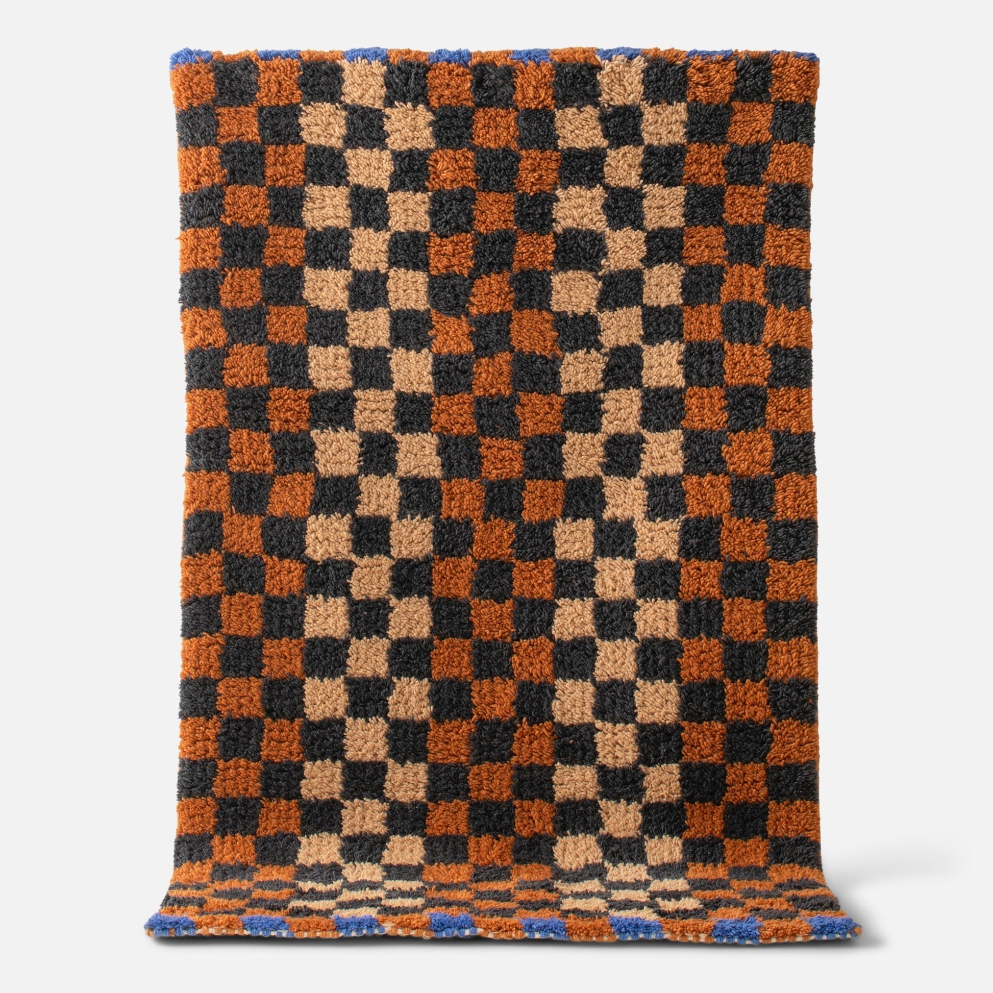 Top view of Schoolhouse x Clare V. Felix shag wool rug showing checkerboard pattern and high-pile texture on white background