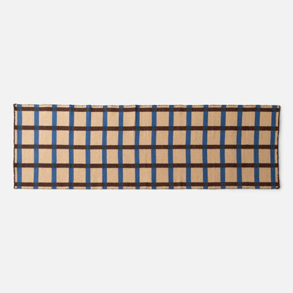 Top edge of Plaid Wool Reversible Rug showing woven beige plaid with blue and brown stripes on white background