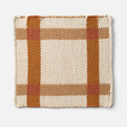 Close up of Plaid Wool Reversible Rug corner showcasing handwoven wool texture and beige and rust plaid on white background