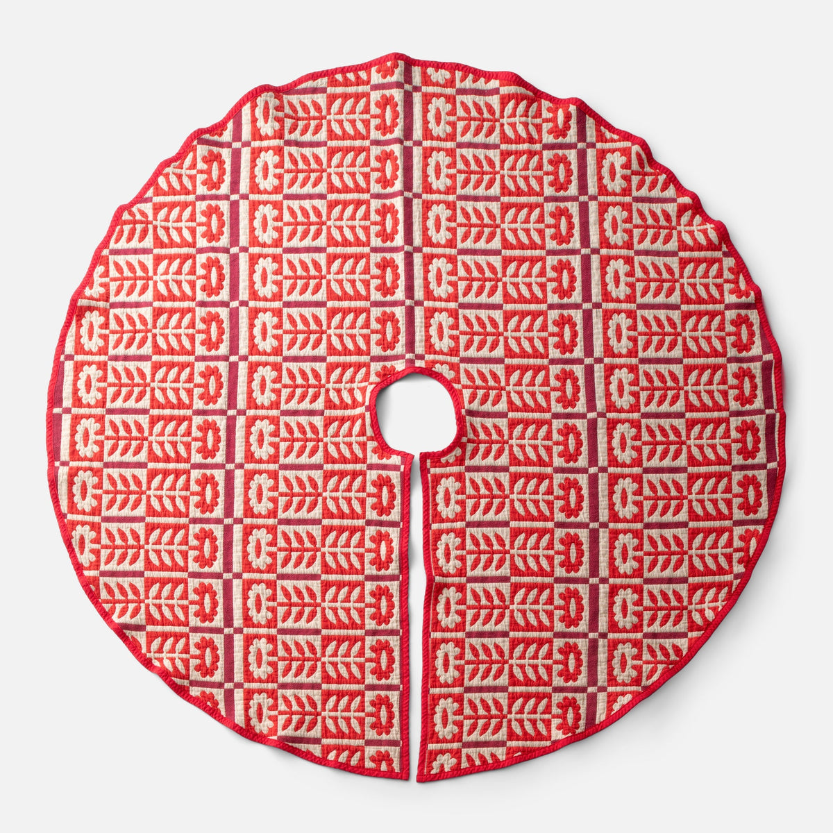 Top view of Stillwater Tree Skirt showcasing red jacquard floral pattern with center opening and slit on a light background