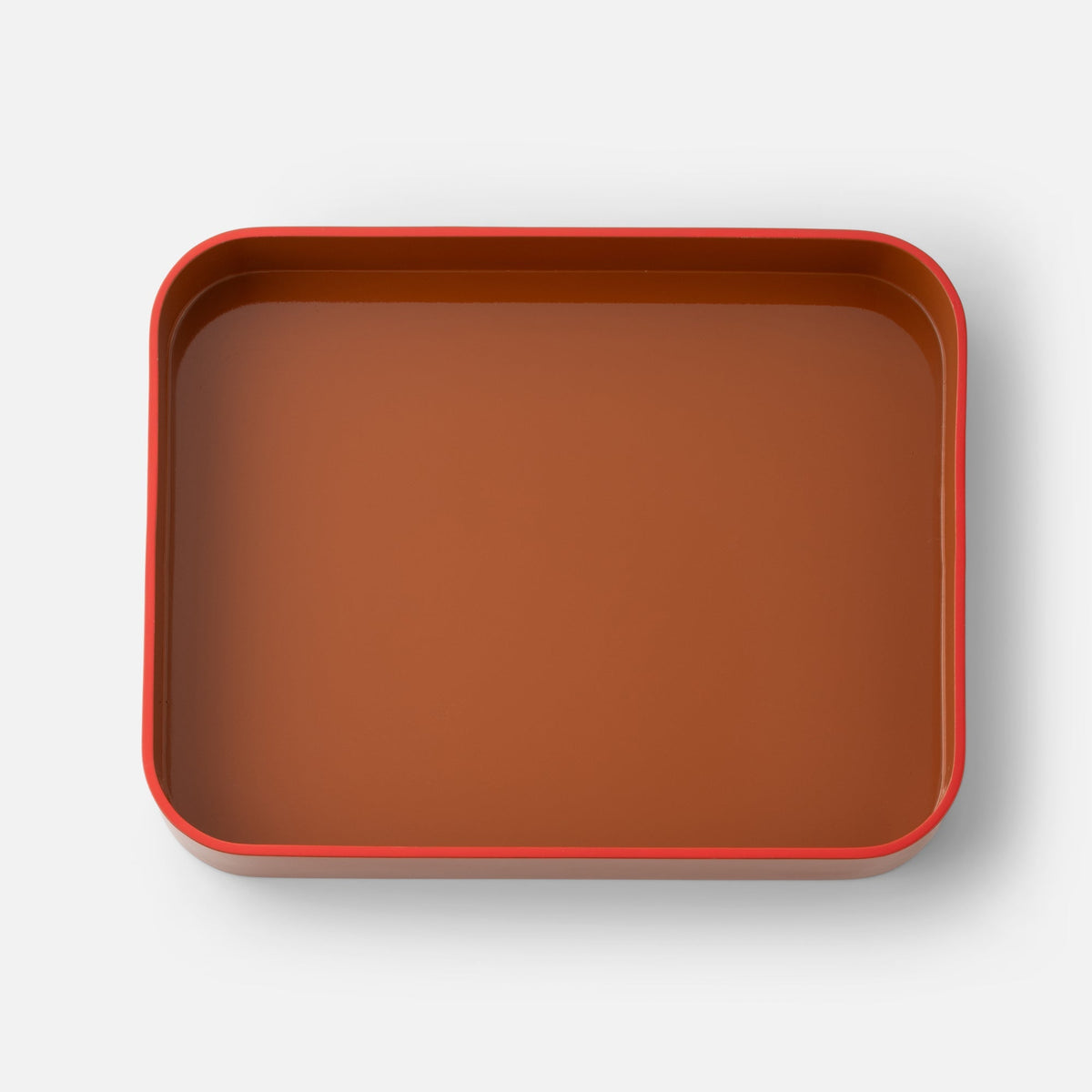 Top view of Clare V Sonia Tray showcasing a red rim and brown interior on a white background