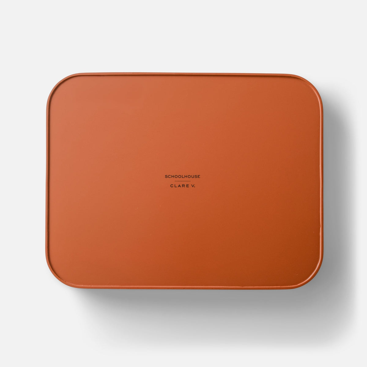 Top view of orange Clare V Sonia Tray showcasing rounded corners and centered Clare V branding on a white background