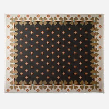 Top view of Flora Wool Flatweave Rug in black showcasing folk-floral pattern, flatweave wool texture on white background