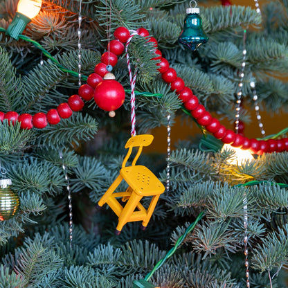 Front view of Utility Chair Ornament showcasing its yellow finish hanging on a decorated Christmas tree