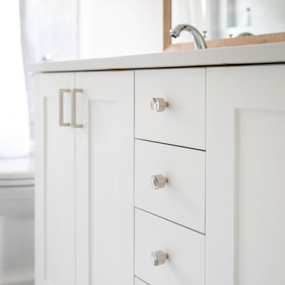 Angled view of Mid Century Knob showcasing its round face on white bathroom cabinetry