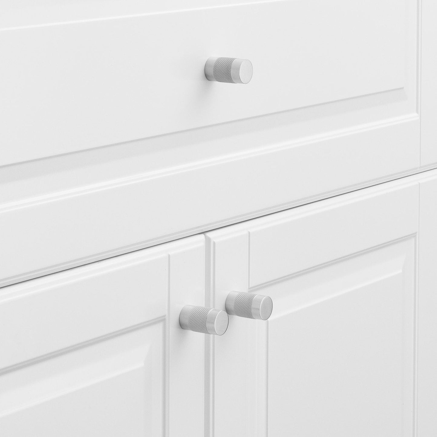 Knurled knobs installed on white paneled cabinet doors