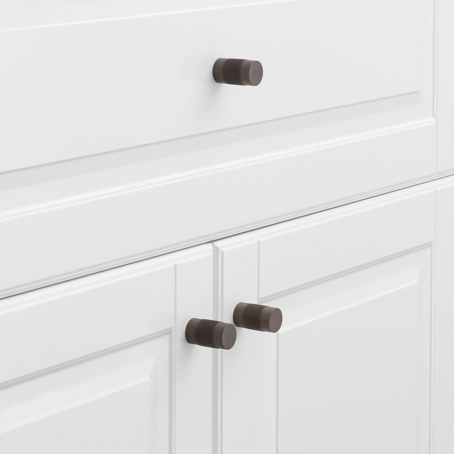 Side view of the Knurled Knob showcasing its cross-hatched texture with white paneled cabinet doors