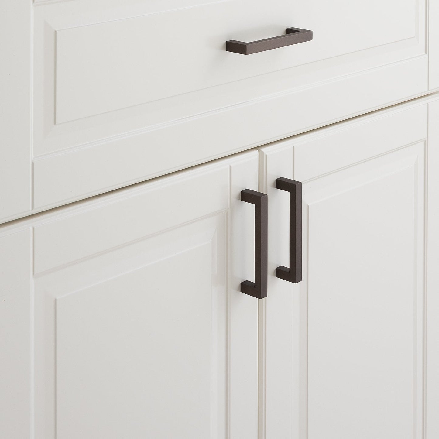 Close-up of Edgecliff Pull showcasing dark rectangular bar pulls on white paneled cabinetry