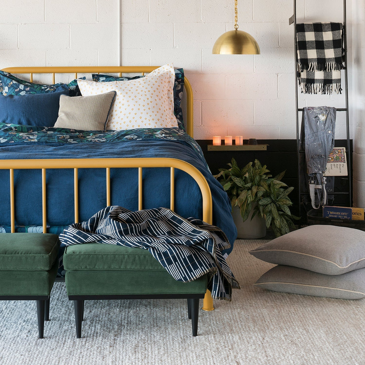 Thistle pillowcases styled on a bed in a colorful bedroom with a gold bed frame and layered bedding
