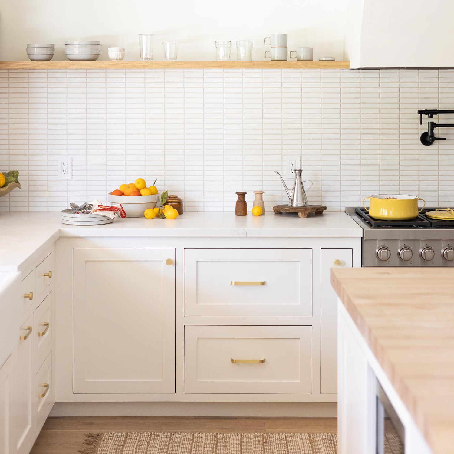 Cascade Pull cabinet pulls installed on cream kitchen cabinetry in a bright kitchen