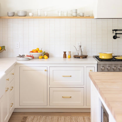 Cascade Pull cabinet pulls installed on cream kitchen cabinetry in a bright kitchen