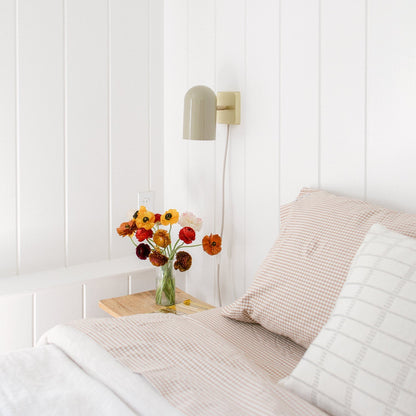 Angled view of gingham pillowcase showcasing its checked pattern with a bright bedroom background